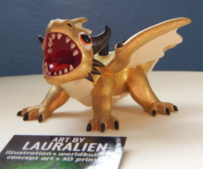 A small statue of a shiny gold dragon. The figurine is roaring, and has big cute eyes.