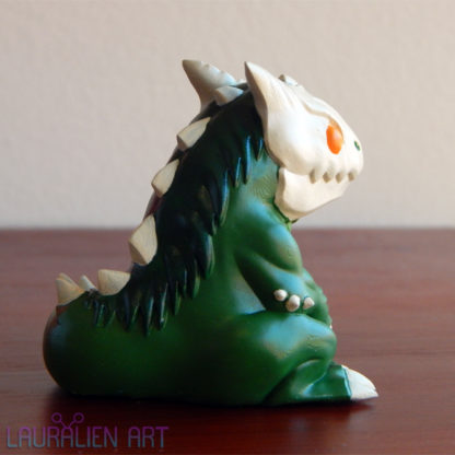 A small, handpainted figurine of SCP-682: a cute lizard monster.