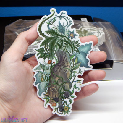 A 5" sticker of a tranquil hyena surrounded by leafy foliage